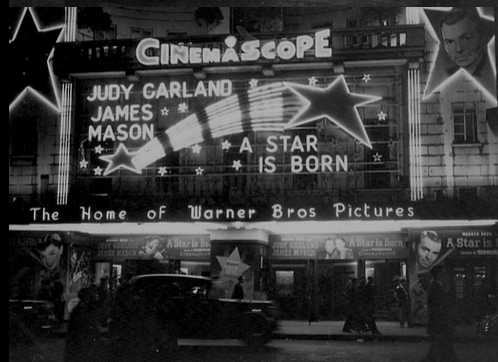 A black and white photo of a cinemascope marquee for Judy Garland and James Mason in A Star is born 