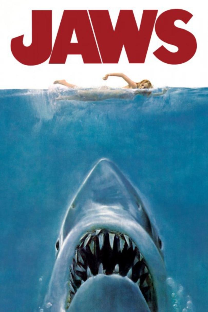 Poster for Jaws (1975) with a shark coming up from the bottom towards a swimmer
